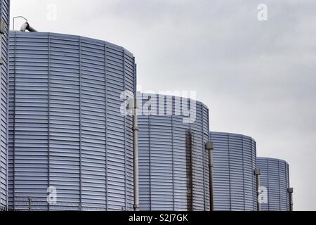 Rangée de silos industriels bleu contre un ciel gris Banque D'Images