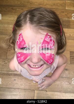 Quatre ans, fille mignonne avec son visage peint avec peinture du visage en style papillon. Banque D'Images