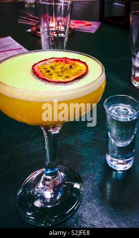Stars martini. Vodka, purée de fruits de la passion, sucre, jus d'orange et de la coupe de fruits de la passion. Servi avec Prosecco chaser. Banque D'Images