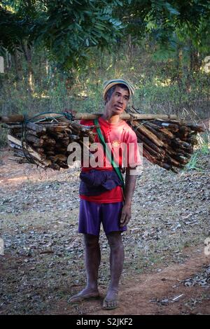 Portrait d'un homme birman transporter le bois. À fatigué et épuisé dans cette scène de la vie quotidienne. Scène rurale à l'intérieur du Myanmar, officiellement connu sous le nom de Birmanie ou Myanmar. Banque D'Images