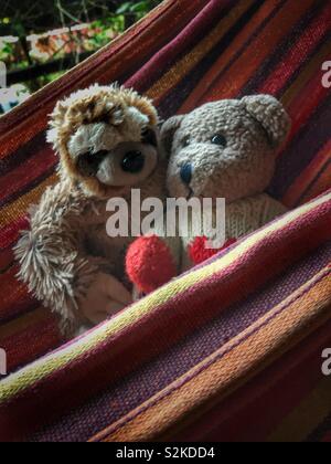 Peluche pals se balançant dans un hamac. Banque D'Images