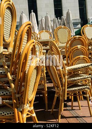 Des piles de chaises en bois et en osier Je suis Barela en attente de l'ouverture d'un café en plein air dans la région de Bryant Park, New York, USA Banque D'Images