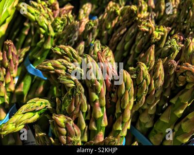 Image complète de produits très frais, délicieux venu vert bleu les asperges sur l'affichage et à la vente à la marché du terroir. Banque D'Images