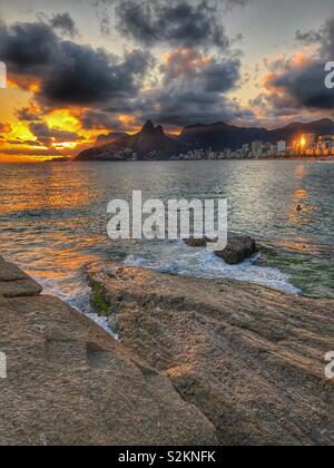 Le soleil se couche sur la mer et les montagnes à Ipanema, Rio de Janeiro, Brésil. Banque D'Images