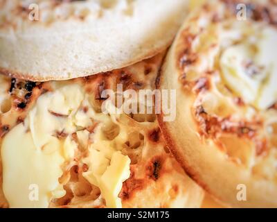 Faire fondre le beurre avec les crumpets chauds. Banque D'Images