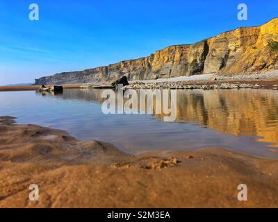 Traeth Mawr, falaises de la côte du Glamorgan, reflétée dans une plage extérieure. Banque D'Images