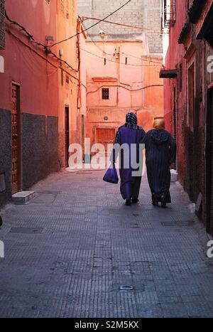 Deux femmes marchant dans la médina de Marrakech en début de soirée. Banque D'Images