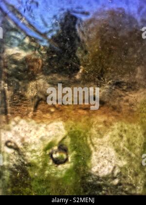 Lumineux décoratif vert, bleu, brun et vitraux colorés en verre translucide texturé avec un motif abstrait aléatoire. Banque D'Images