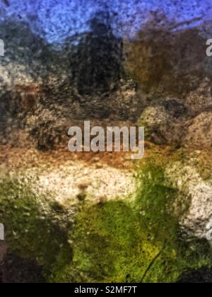 Vitraux colorés décoratifs en verre translucide texturé avec un motif abstrait aléatoire. Banque D'Images