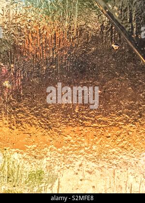 Vitraux de couleur orange décoratifs en verre translucide texturé avec un motif abstrait aléatoire. Banque D'Images