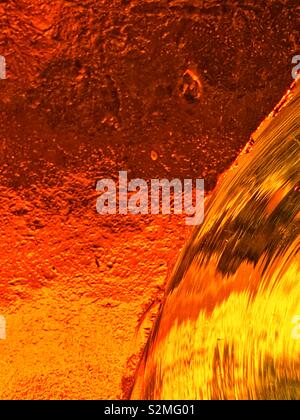 Colorés décoratifs colorés rouge et orange en verre translucide texturé avec un motif abstrait aléatoire. Banque D'Images