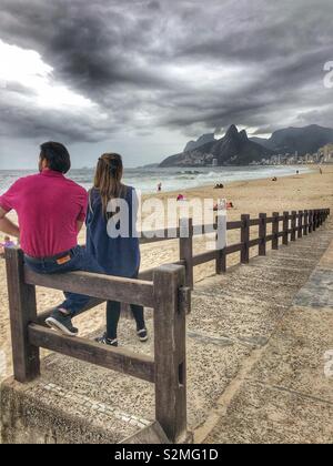 Un couple en profitant de la vue de la plage d'Ipanema à Rio de Janeiro, Brésil. Banque D'Images