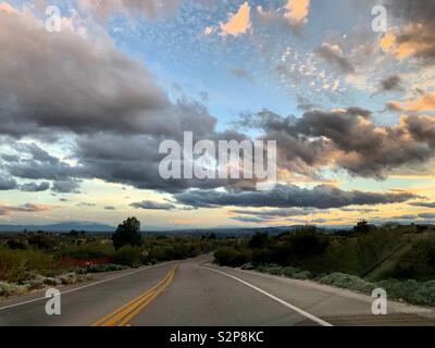 Ciel ouvert au coucher du soleil sur la route vide Banque D'Images