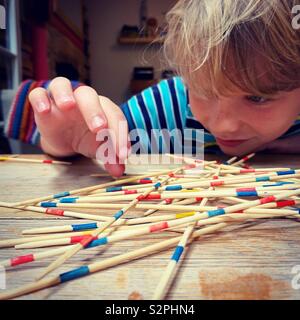 Garçon jouant Pickup Sticks Banque D'Images