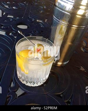 Un cocktail martini sur les rochers dans un verre de cristal à côté de shaker sur une terrasse extérieure avec table, USA Banque D'Images