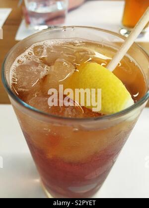 Un verre de thé glacé avec un quartier de citron servi dans un restaurant avec un papier paille pour protéger l'environnement, United States Banque D'Images