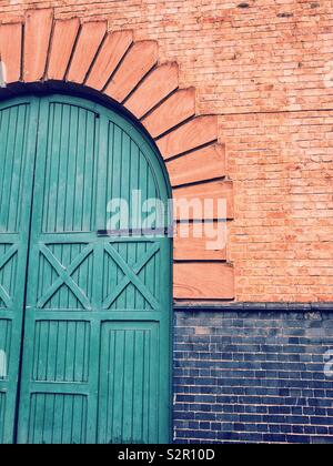 Grande porte en bois en briques rouges. Banque D'Images