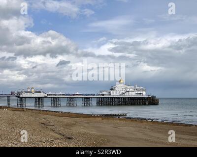 Eastbourne Pier, East Sussex, Royaume-Uni depuis la plage à marée basse, le jour du printemps, avec des nuages de tempête au loin. Banque D'Images