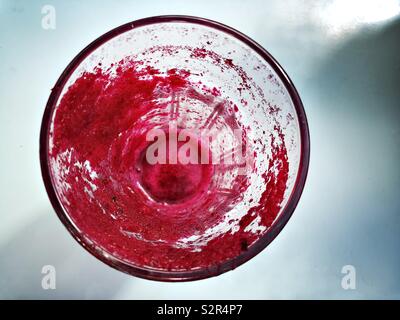 Image abstraite d'un verre avec les textures créées par résidu de jus de betteraves rouges photographiés en vue de dessus Banque D'Images