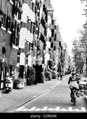 Fille en vélo le long de la rue d'Amsterdam en noir et blanc Banque D'Images