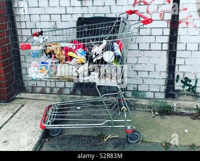 Chariot d'achat abandonné pleine de détritus Banque D'Images