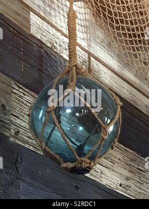 Globe en verre vert enveloppé dans Ancien filet de pêche Banque D'Images