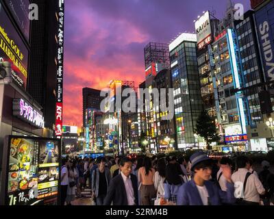 Les gens marcher contre le coucher du soleil à Shinjuku, Tokyo, Japon. Banque D'Images