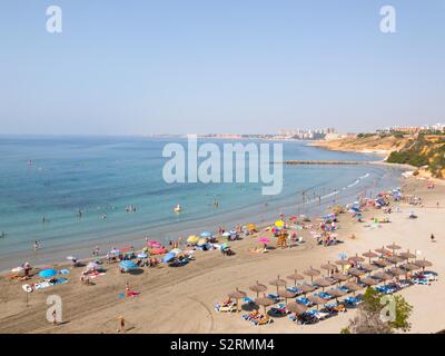 Orihuela Costa, Alicante, Espagne - Juillet 2019 - vue de gens en train de bronzer sur la plage de Cabo Roig dans le matin Banque D'Images