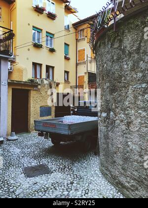 Petite camionnette transportant des bouteilles d'eau parking dans coin de rue Italien Banque D'Images