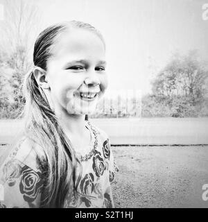 Portrait noir et blanc de 7 ans, fille, smiling at the camera Banque D'Images