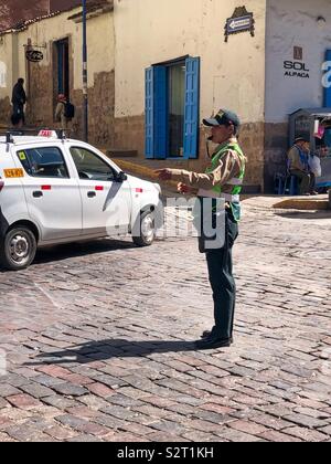 La police de la circulation péruvienne policier diriger la circulation sur une rue pavée à Cusco Cuzco Pérou Le Pérou. Banque D'Images