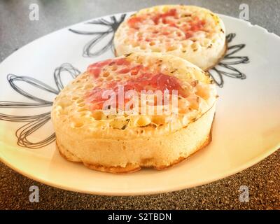 Deux crumpets avec confiture et beurre Banque D'Images