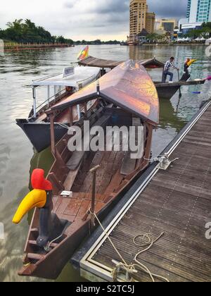 Bateaux traditionnels malais utilisé pour les touristes des croisières sur la rivière Sarawak, Kuching, Sarawak, Malaisie ; (avant) Orang Ulu bateau, (arrière) Iban longboat, avec comme figures de proue en bois oiseaux calao Banque D'Images