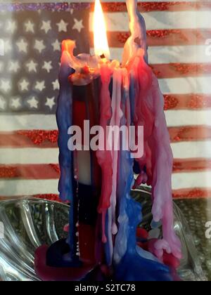 Rouge Blanc et bleu bougie brûler devant un drapeau américain Banque D'Images