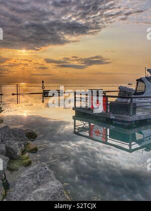 Coucher du Soleil reflété sur le lac Ontario à Port Dalhousie. Banque D'Images