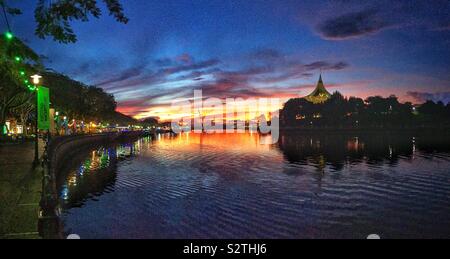 La cité au bord de l'eau sur la rive sud de la rivière Sarawak au coucher du soleil, Kuching, Sarawak, Malaisie Banque D'Images