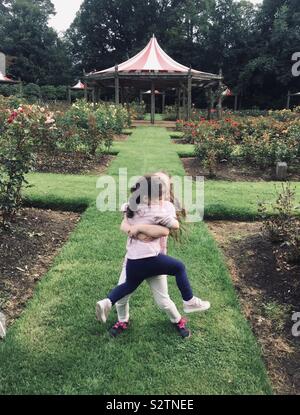 Sœurs hugging in park à Belfast en Irlande Banque D'Images