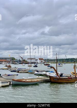 Woodbridge, Suffolk, UK - 16 août 2019 : bateaux amarrés sur la rivière Deben avec le moulin à marée au loin. Banque D'Images