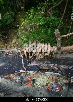 Un enchevêtrement de filets de pêche et les bouteilles en plastique s'est échoué sur la plage, avec du sable coloré par des eaux souterraines polluées, détroit de Malacca, près de Lumut, Perak, Malaisie Banque D'Images