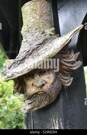 Sculpture en bois d'un assistant à la figure taillée dans un tronc d'arbre Banque D'Images