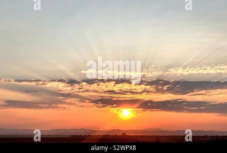 Rayons à travers les nuages pendant le lever du soleil sur la montagne d'or Banque D'Images