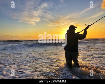 Dans le casting de pêcheurs de surf à Llangennith, Gower, Swansea, Pays de Galles du Sud-Ouest, août. Banque D'Images