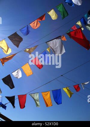 Drapeaux colorés voler contre un ciel bleu au-dessus d'un bateau pirate amarré à Tampa, en Floride. Banque D'Images