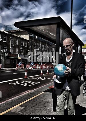 Homme tenant un globe dans sa main à Londres Banque D'Images