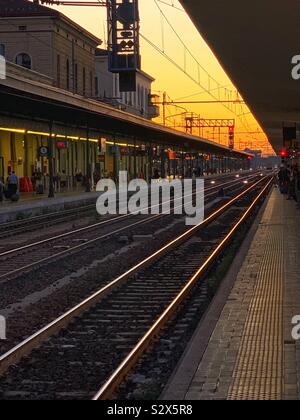 Coucher du soleil sur les rails à la gare centrale de Bologne. L'Italie. Banque D'Images