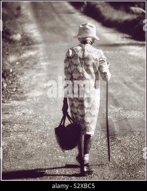 Une vieille dame avec un bâton de marche dans les régions rurales de la Jamaïque. Banque D'Images