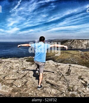 L'homme sur falaise, pratiquant le Kung Fu se déplace à Tintagel château avec vue sur l'océan Atlantique, Cornwall UK Banque D'Images