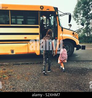 Les enfants de monter dans un autobus scolaire Banque D'Images