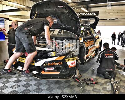 Dan Cammish Garage fosse à Silverstone BTCC 2019 avec les mécaniciens travaillant sur sa voiture Banque D'Images