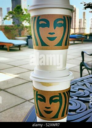 Aller à Starbucks coffee cups empilés sur une table sur un immeuble toiture-terrasse à Midtown Manhattan, New York, USA Banque D'Images
